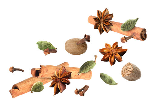 Different spices for Christmas drinks and dishes. Anise, cardamom, cinnamon, nutmeg and clove falling on white background - Powered by Adobe