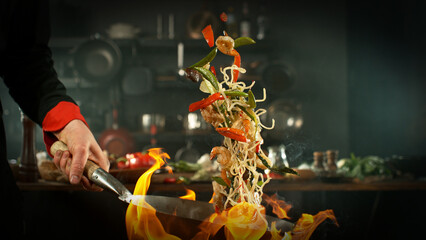 Obraz premium Freeze Motion of Flying Asian Meal with Vegetable and Prawns into Wok Pan