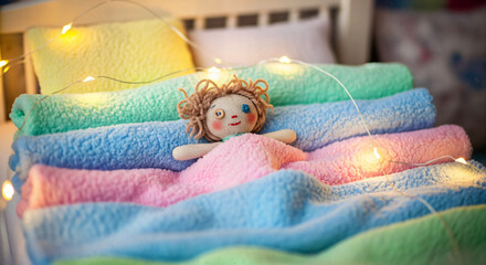 Adorable handmade doll resting peacefully on soft pastel blankets with twinkling fairy lights for a cozy, dreamy, and comforting vibe