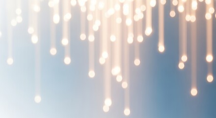 Soft focus glowing light streaks and bokeh orbs descending against a gradient blue background, abstract festive celebration or holiday illumination