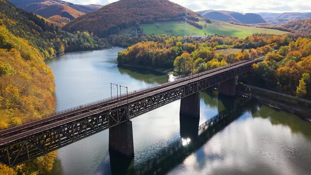 Ružinsk&yacute; Viadukt, a majestic 19th-century iron railway masterpiece, gracefully spans the serene Horn&aacute;d River beneath the Ruž&iacute;n reservoir in eastern Slovakia. Captured in golden autumn light.