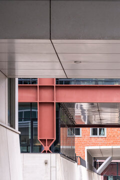 Commercial architecture facade expression constructed through geometry, structure, contrast and lines, featuring balanced composition, a sharp red highlight, shadow interaction and pattern.