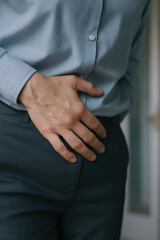 Obraz premium Man clutching stomach in morning with hand on abdomen showing pain health routine discomfort