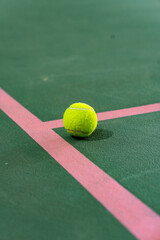 Bright Yellow Tennis Ball Centered on Intersecting Pink Court Lines