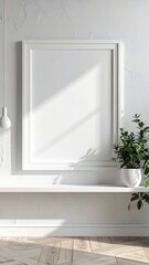 Empty white frame on a shelf with plant and sunlight.