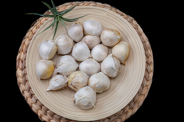 Solo garlic cloves filling a bamboo bowl