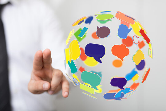 Abstract image of a person touching a digital globe with colorful speech bubbles. Concept of communication, social media, and global connections