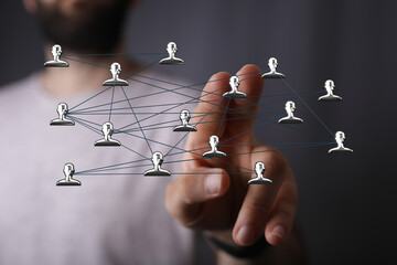 Close-up of a hand interacting with a network concept with people icons. Illustrating connection, communication, and digital technology. Concept