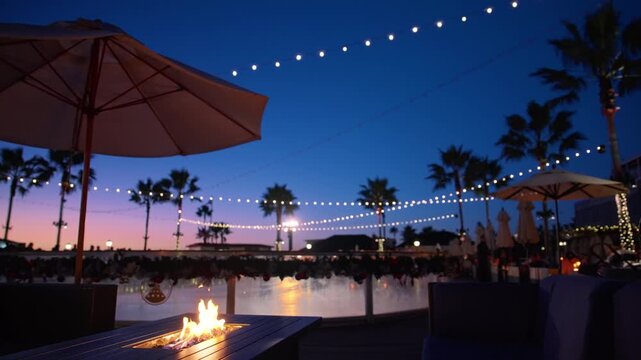 sunset poolside bistro with umbrella string lights glow above marina, fire pit flickers on wooden table, warm