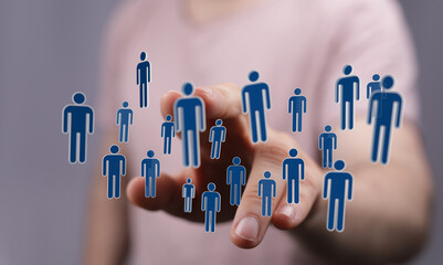 Concept of social networking, teamwork, cooperation, and partnership. Symbols of people are projected from the hand, representing community and