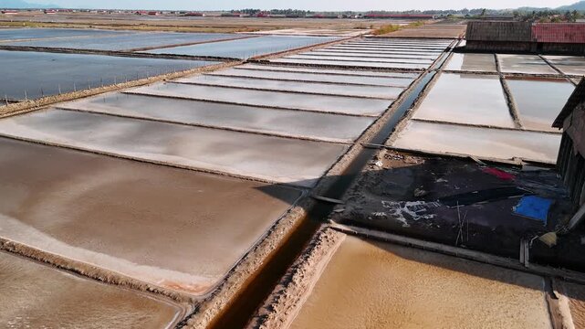 Aerial view of the kampot salt fields in cambodia, showing the intricate network of evaporation ponds for natural sea salt production.