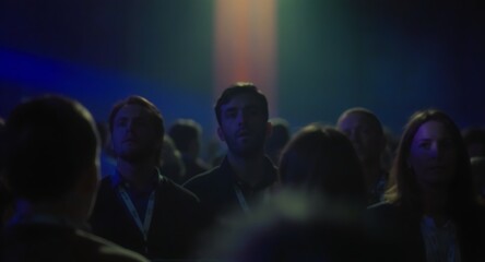 Attendees in a Conference Hall Observing Presentation and Engaging with the Speakers