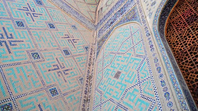 Pan shot of the ornate facade of Bibi Khanym Mosque in Samarkand, Uzbekistan, displaying detailed Islamic geometric decoration.