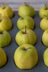Fresh apples arranged in a baking pan, ideal for culinary guides, meal-planning designs, diet content, and kitchen-themed projects.