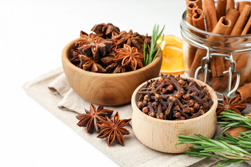 Different spices, fresh rosemary and dry orange slices for mulled wine on white table
