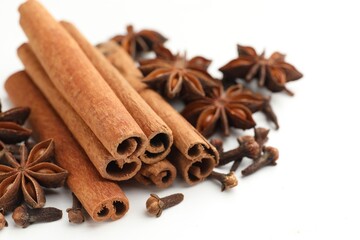 Mulled wine spices. Cinnamon sticks, anise stars and cloves on white wooden table, closeup