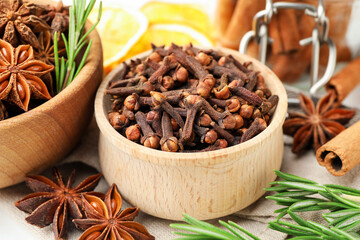 Different spices, fresh rosemary and dry orange slices for mulled wine on table, closeup