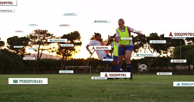 Playing players in neon vests sliding, controlling ball on school field at sunset with ID labels - Powered by Adobe