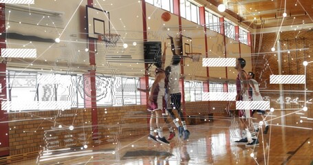 Jumping players wearing team jerseys contesting shot under hoop on school gym, ball AR overlay