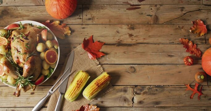 Displaying roasted turkey on platter sitting on home table, with carving fork, corn, copy space