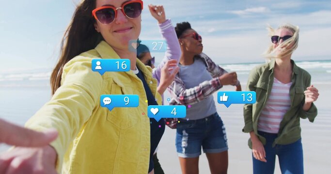 Taking woman in yellow jacket holding smartphone for selfie at ocean beach, with reaction overlays - Powered by Adobe