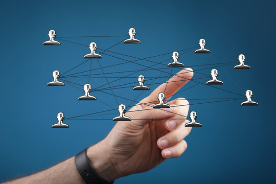 Hand pointing at network of people, digital connections, data exchange, global community, teamwork, and social interaction.