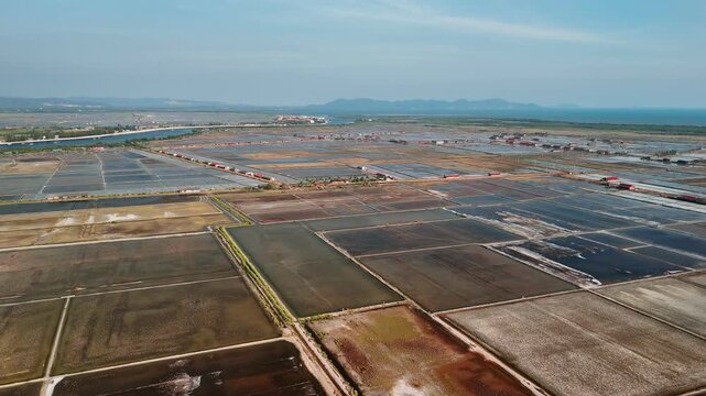 Aerial view of traditional salt fields in kampot, cambodia. Geometric fields filled with seawater for natural evaporation.