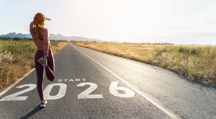 New year 2026 or start straight concept.word 2026 written on the asphalt road and athlete woman...