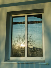 A window with a view of the sun setting through it