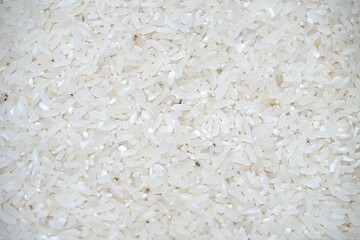 Dry Uncooked White Rice Background - Top View, Flat Lay. Scattered Raw Long Grain Rice. Asian Cuisine and Culture. Healthy Eating Ingredients. Diet Food