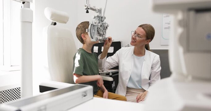 Optometrist examining boy vision with phoropter equipment