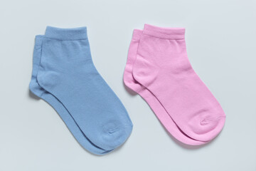 Blue and pink children socks isolated on grey background for boy and for girl.