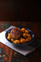 Fried meatballs with potatoes on a rustic background. Selective and soft focus.	