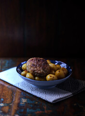 Fried meatballs with potatoes on a rustic background. Selective and soft focus.	