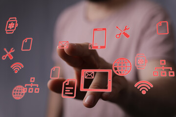 A person's hand interacting with holographic icons representing communication, data management, and network con