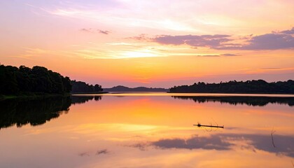 Obraz premium A tranquil lake reflects a colorful sunset sky with hues of orange, pink, and purple, bordered by dark, tree-covered shores.