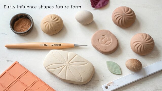 Diverse unshaped clay lumps and crafting tools with imprinted patterns on a flat surface, highlighting creative potential and tactile artistry