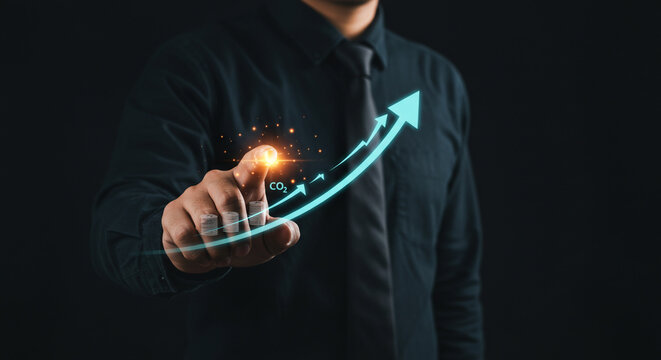 Man's hand points to rising CO2 emissions graph with stacked coins illustrating financial impact, symbolizing environmental and economic challenges.