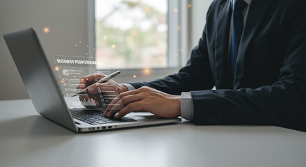 Professional businessman analyzing business performance data on a laptop with glowing digital interface, driving growth.