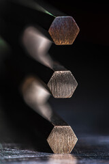 Non-ferrous metal rods on a metal surface close-up in a dark, industrial space