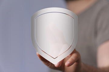 Concept image of a hand holding a shield, representing protection, security, safety, and defense....
