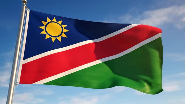 Namibia Flag Waving in the Sky - A vibrant Namibian flag waves proudly against a backdrop of a clear, blue sky with a few wispy clouds.