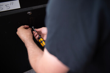 Montage einer TV-Wandhalterung &ndash; Hand befestigt Halterung mit Schraubendreher