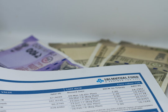 Currency notes, coins and an SBI Mutual Fund sheet showcasing NAV details, financial planning elements and investment insights for investors tracking market performance and evaluating portfolio growth