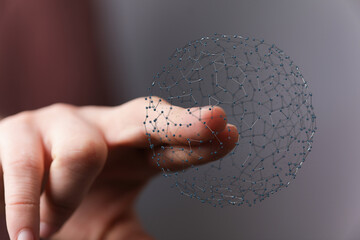 Close up of hand holding 3D network sphere. Concept of global network, data, and communication....