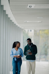 Colleagues walking and discussing business on tablet
