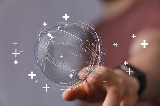 Concept of global network and digital technology. A hand touching a globe with digital overlay, representing data connection and the future.