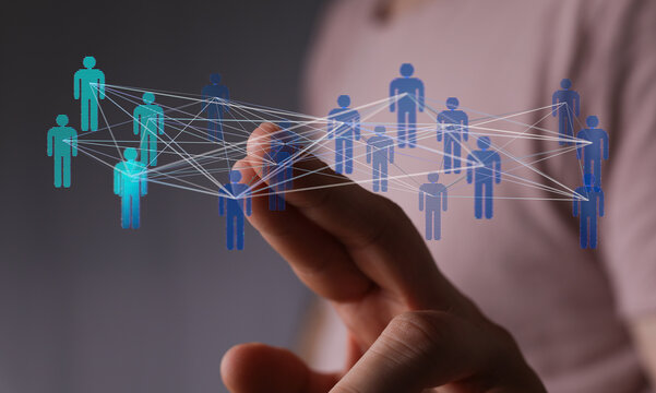 Concept of teamwork and communication in the digital age. Person touching the holographic network of people. - Powered by Adobe