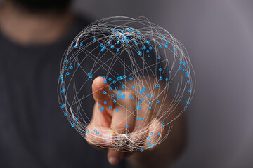 Close-up of a person's hand touching a digital globe symbolizing global connection and network. Technology concept, data visualizatio