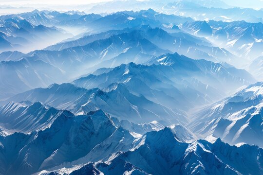 Aerial view of endless snowy mountain ranges fading into the horizon, creating a stunning landscape
